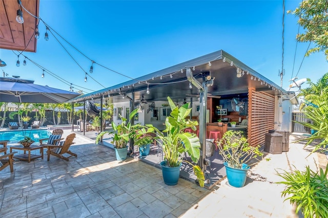 view of patio featuring exterior bar and a fenced in pool