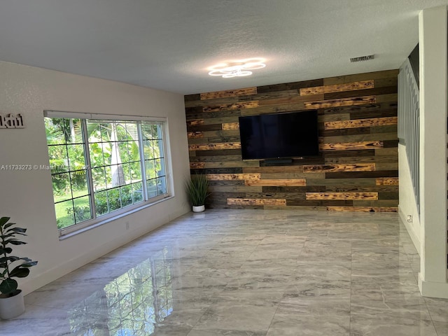 living room with a textured ceiling and wood walls