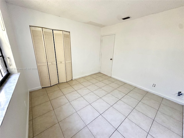 unfurnished bedroom with a textured ceiling and a closet