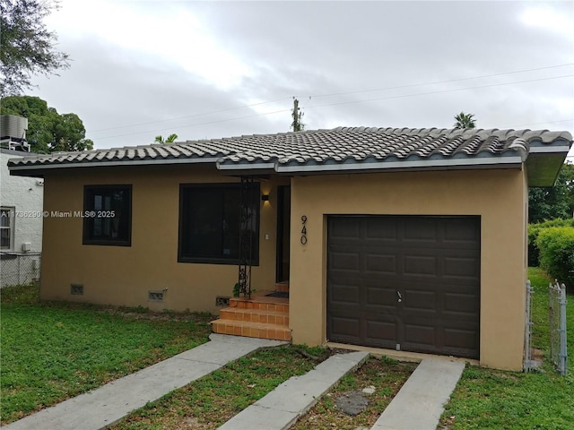 view of front of property with a garage, central AC, and a front yard