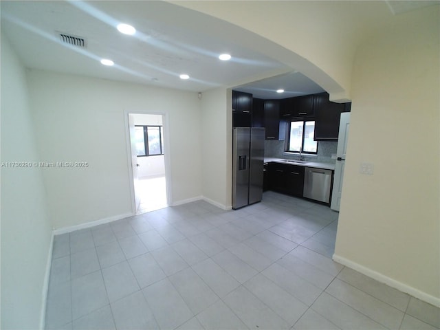 kitchen featuring tasteful backsplash, stainless steel appliances, sink, and light tile patterned floors