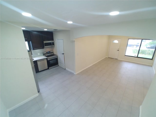 kitchen featuring stainless steel appliances, tasteful backsplash, and vaulted ceiling