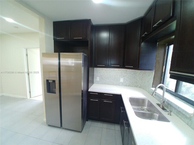 kitchen with sink, backsplash, light tile patterned floors, and stainless steel refrigerator with ice dispenser