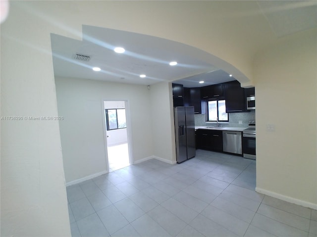 kitchen with tasteful backsplash, sink, light tile patterned floors, and stainless steel appliances