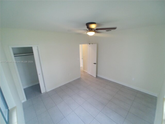 unfurnished bedroom featuring light tile patterned floors, ceiling fan, and a closet