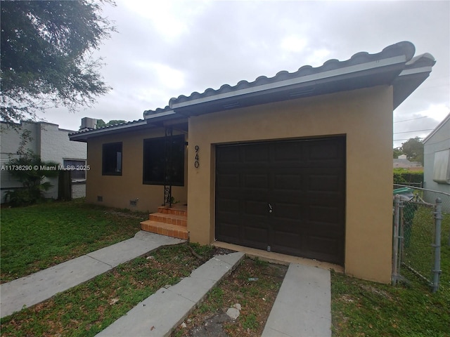 view of front of property featuring a garage and a front lawn