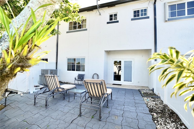 rear view of house featuring a patio and stucco siding