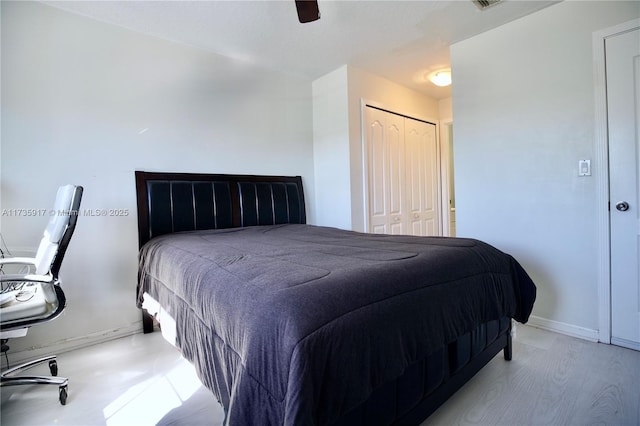 bedroom featuring light hardwood / wood-style flooring, a closet, and ceiling fan