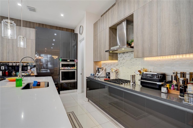 kitchen featuring light tile patterned floors, visible vents, wall chimney range hood, tasteful backsplash, and modern cabinets