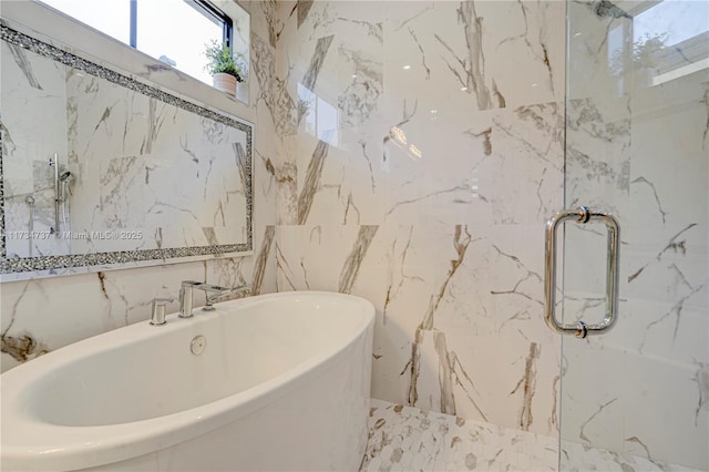 bathroom featuring a freestanding tub and a marble finish shower