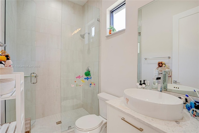 bathroom featuring toilet, a shower stall, and vanity