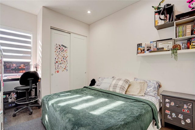 bedroom with a closet, wood finished floors, and recessed lighting