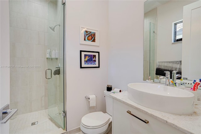 full bath featuring a stall shower, vanity, and toilet