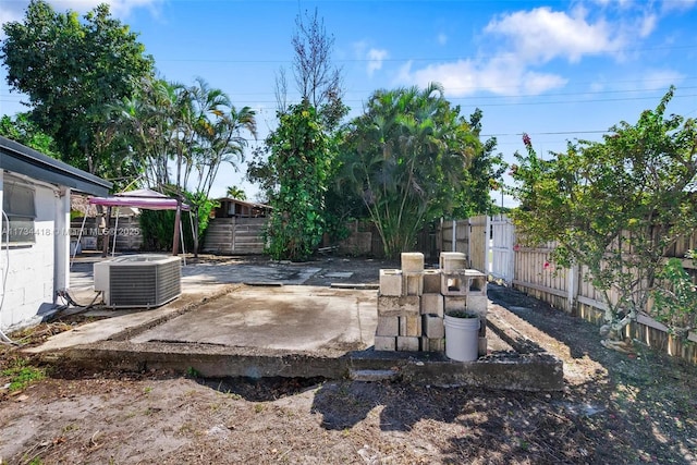 view of yard with cooling unit and a patio