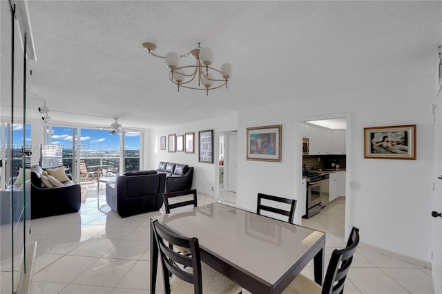 tiled dining space with ceiling fan with notable chandelier, floor to ceiling windows, and a textured ceiling