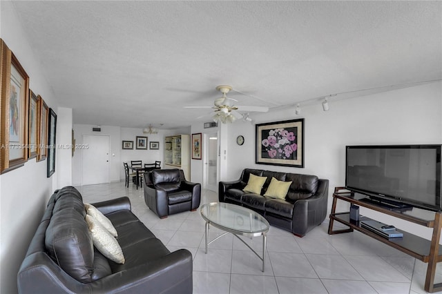 tiled living room featuring ceiling fan, rail lighting, and a textured ceiling