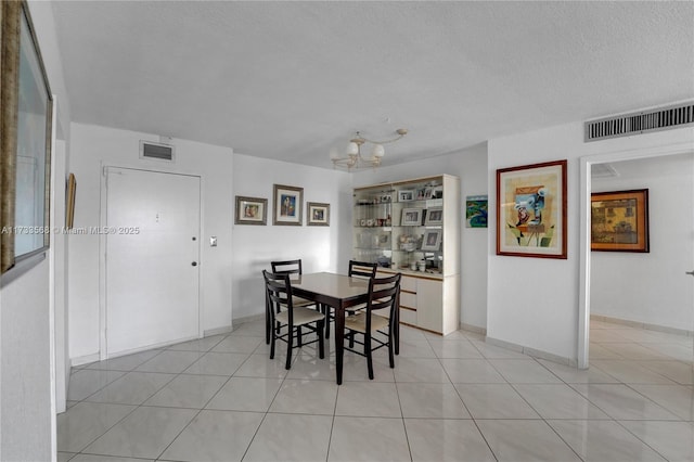 dining space with light tile patterned floors and a textured ceiling