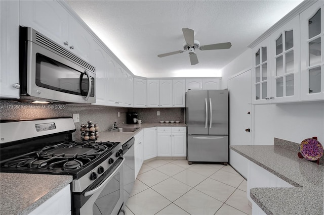 kitchen featuring sink, white cabinetry, tasteful backsplash, a textured ceiling, and appliances with stainless steel finishes