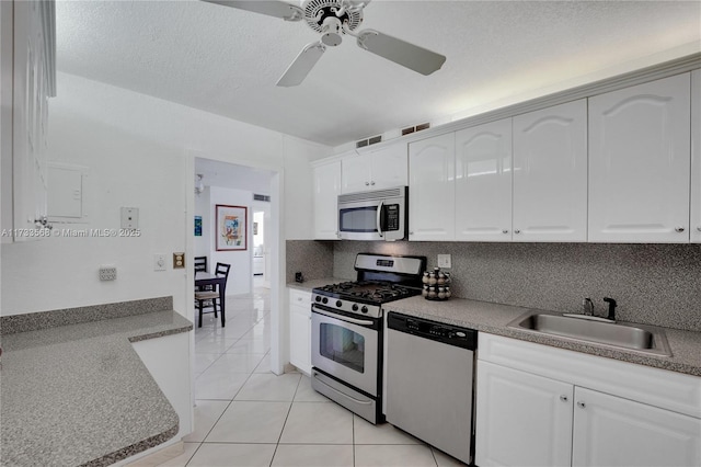 kitchen with appliances with stainless steel finishes, sink, and white cabinets