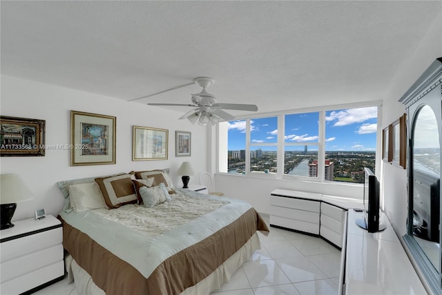 bedroom featuring light tile patterned floors, a textured ceiling, and ceiling fan