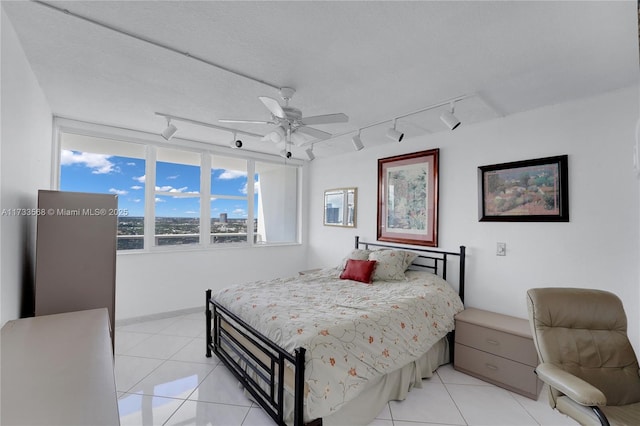 tiled bedroom featuring ceiling fan and a textured ceiling