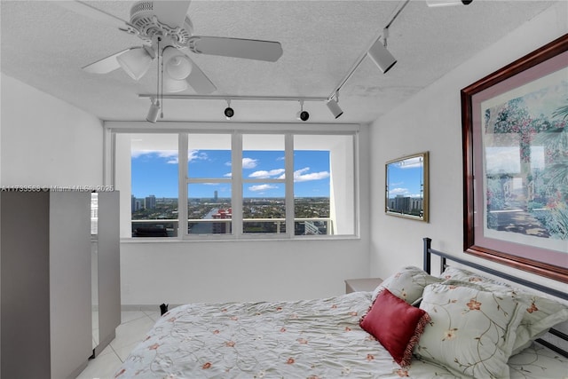 bedroom with light tile patterned floors, a textured ceiling, and ceiling fan