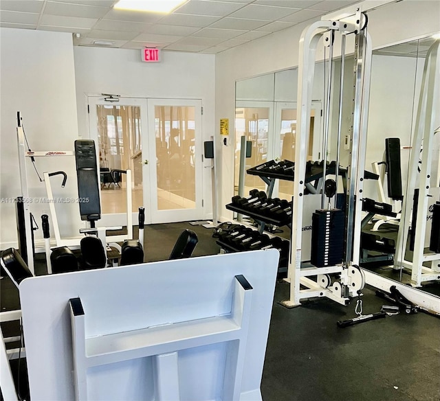 gym with a drop ceiling and french doors