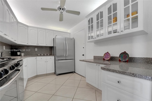 kitchen featuring stainless steel appliances, tasteful backsplash, light stone countertops, and white cabinets