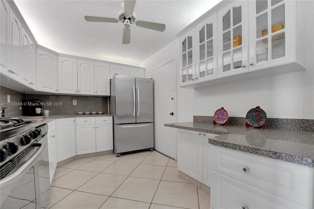 kitchen featuring white cabinetry, light stone counters, decorative backsplash, and appliances with stainless steel finishes