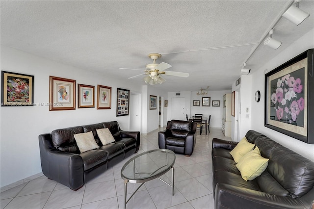 living room with light tile patterned flooring, rail lighting, ceiling fan, and a textured ceiling