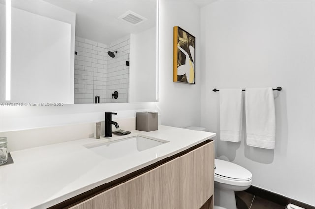 bathroom featuring vanity, tile patterned flooring, toilet, and walk in shower