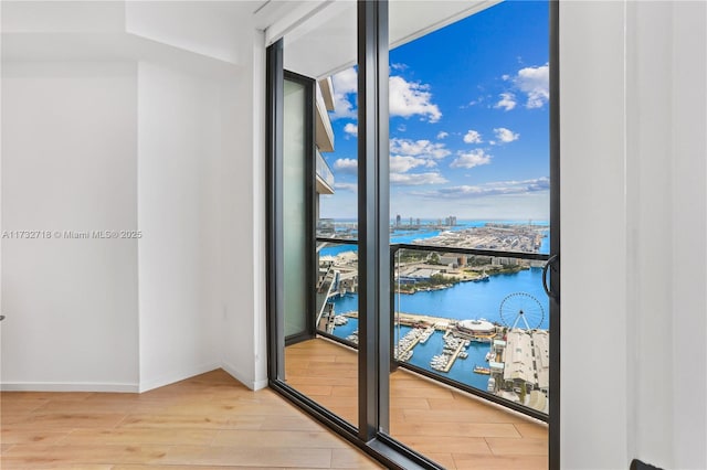 entryway featuring a water view, a wall of windows, and hardwood / wood-style floors