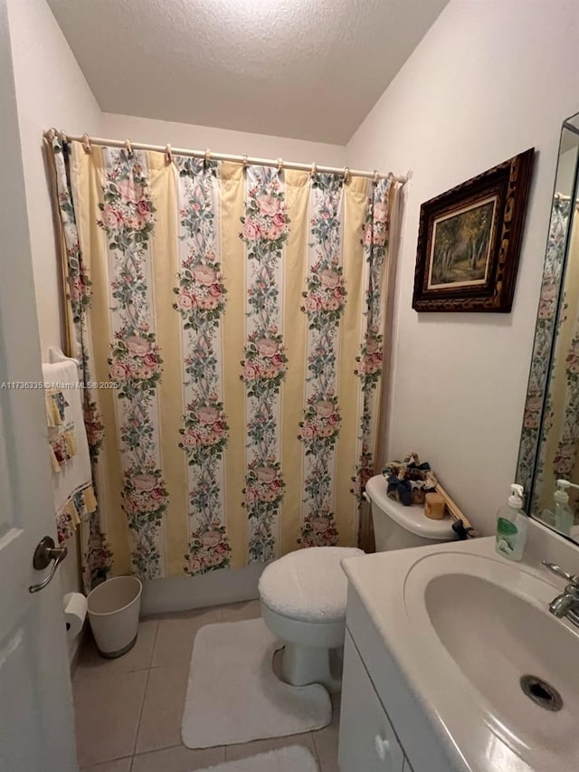 bathroom featuring toilet, a shower with curtain, a textured ceiling, vanity, and tile patterned flooring