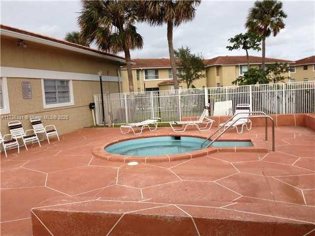 view of swimming pool featuring a community hot tub and a patio