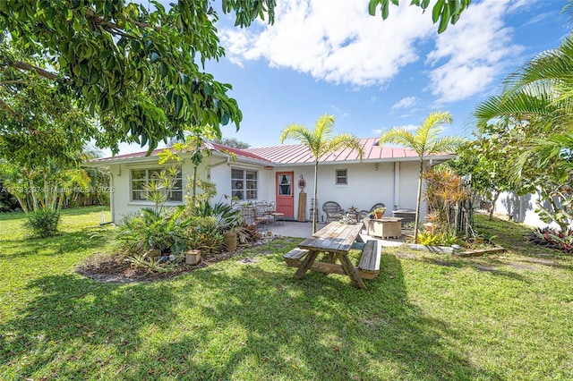 rear view of house with a patio and a lawn