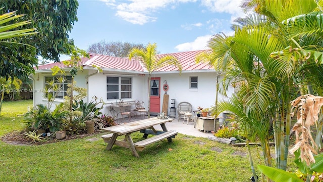 back of house with a lawn and a patio area