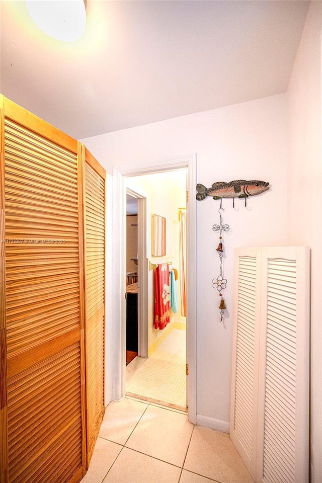 hall featuring light tile patterned floors