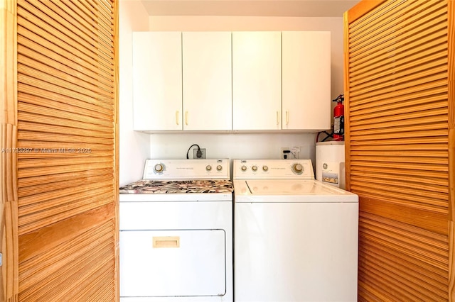 clothes washing area featuring cabinets and washing machine and clothes dryer