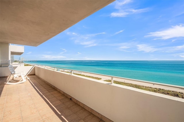 balcony featuring a beach view and a water view