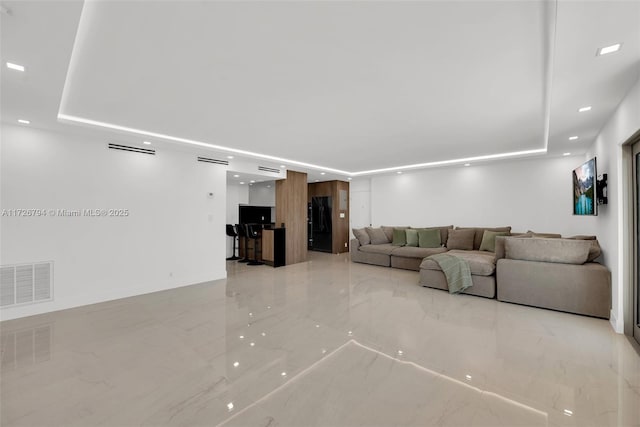 unfurnished living room with a raised ceiling