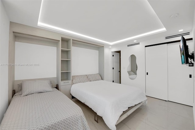 bedroom featuring a raised ceiling and a closet