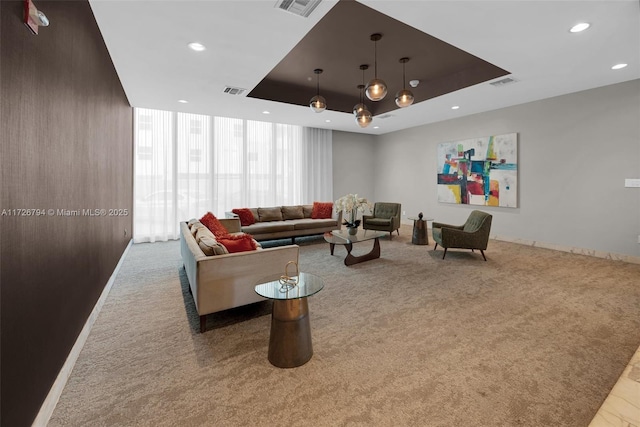 carpeted living room featuring a tray ceiling