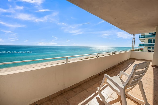 balcony featuring a beach view and a water view