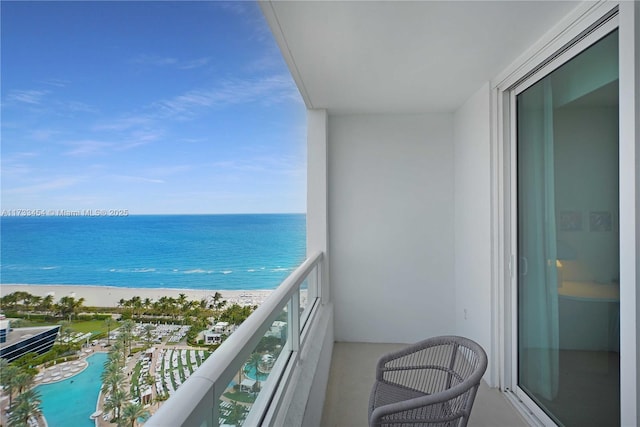 balcony featuring a water view and a beach view