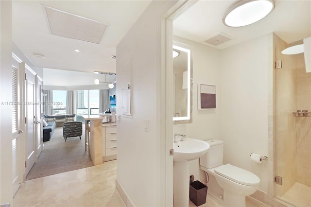 bathroom featuring sink, a shower with shower door, and toilet