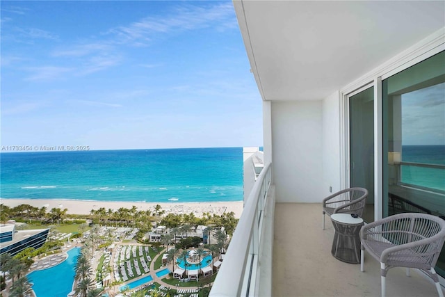 balcony featuring a water view and a view of the beach