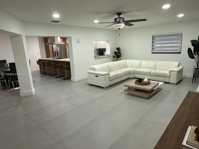 tiled living room featuring sink and ceiling fan