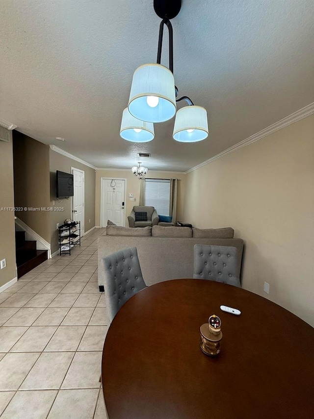 dining area with ornamental molding, a textured ceiling, and light tile patterned floors