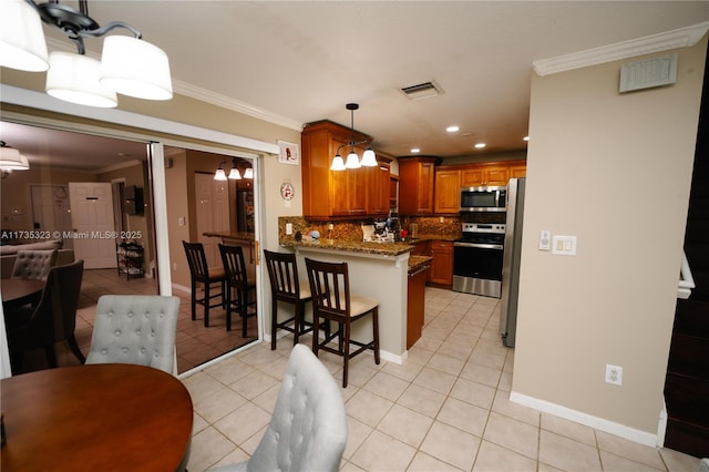 kitchen featuring crown molding, a breakfast bar area, stainless steel appliances, stone countertops, and kitchen peninsula