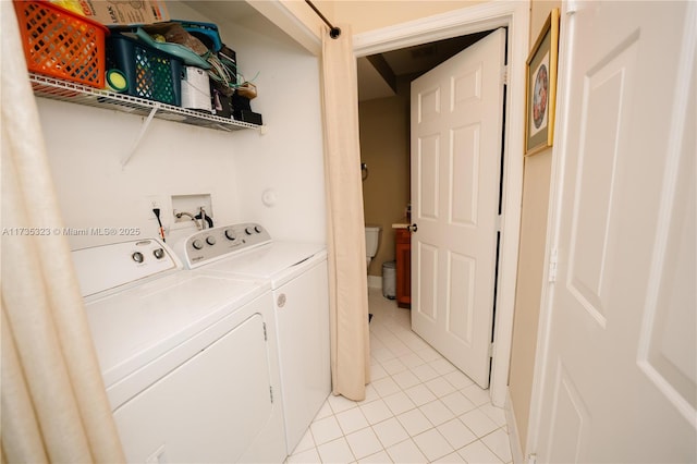 washroom with washer and clothes dryer and light tile patterned floors